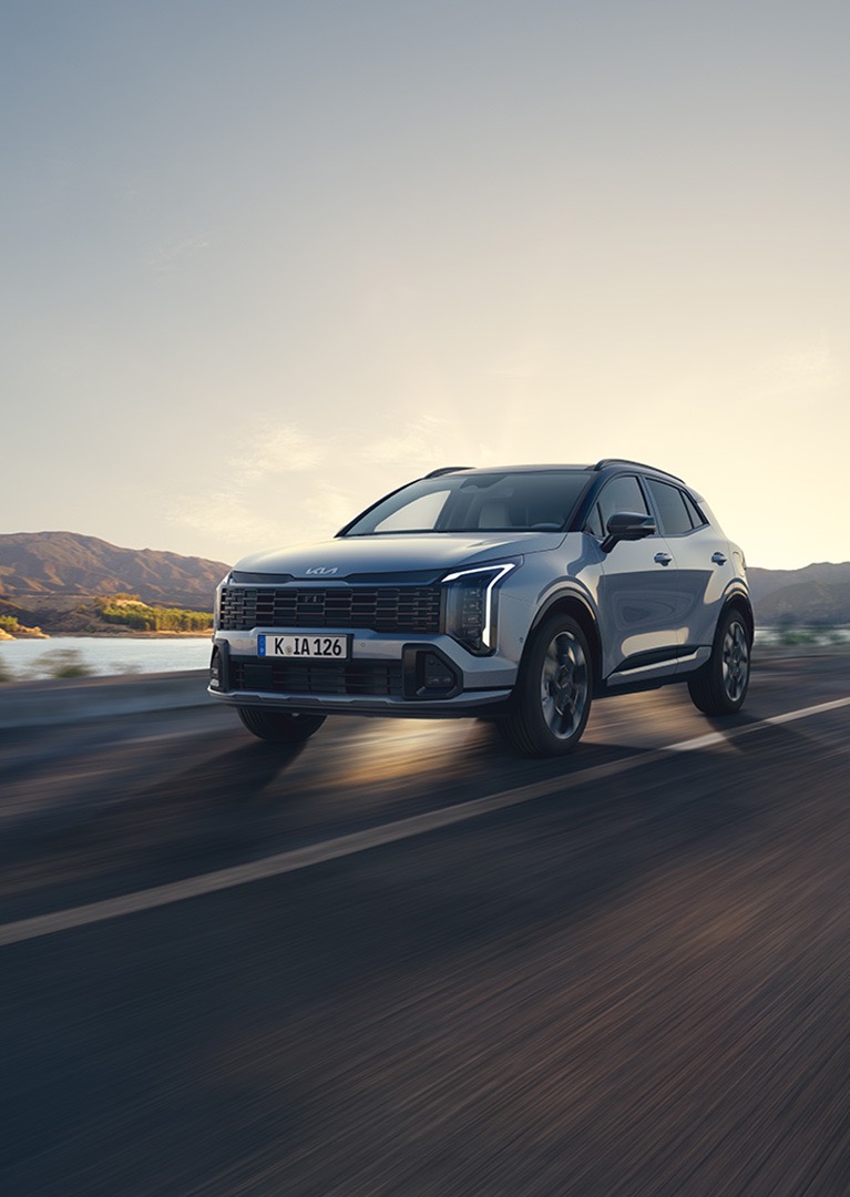 KIA Sportage fährt die STraße herunter.