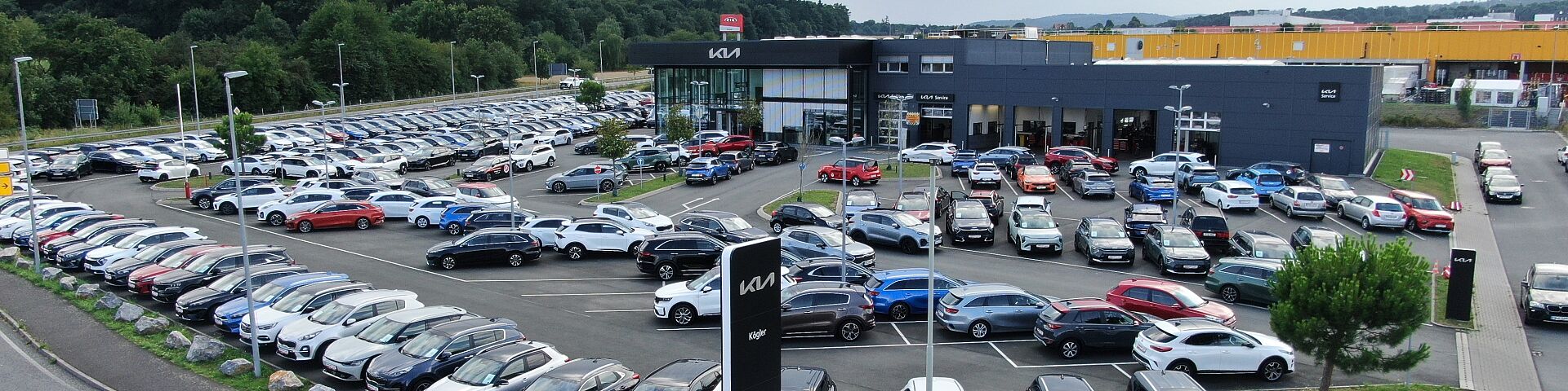 Luftbild des Kia Autohauses KÖGLER mit Fahrzeugbestand vor der Halle